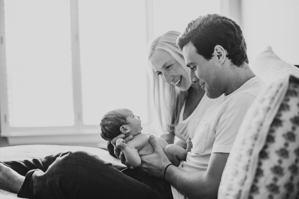 mom and dad full of joy looking at baby