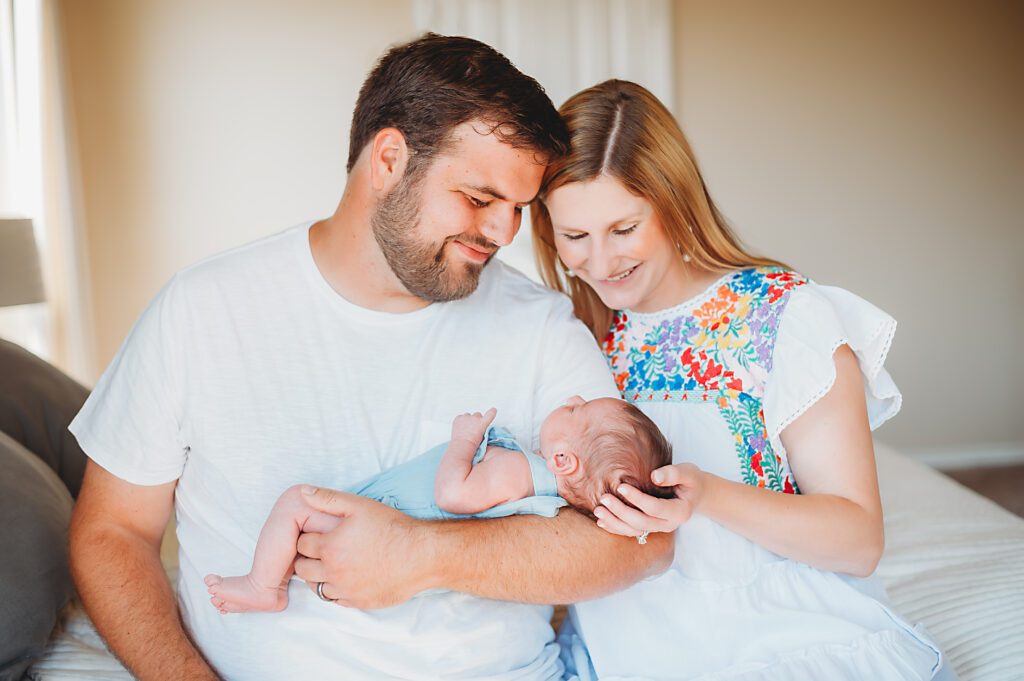 mom and dad smiling at newborn baby dfw newborn lifestyle session