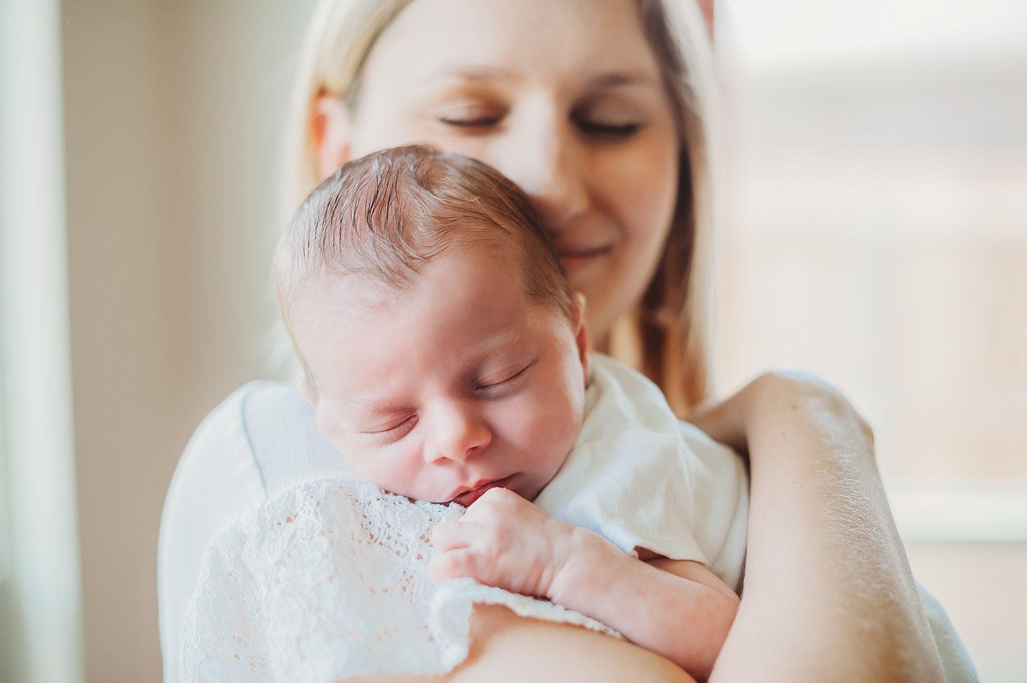 mom snuggles newborn baby on Fort Worth newborn photography session with splendor photography
