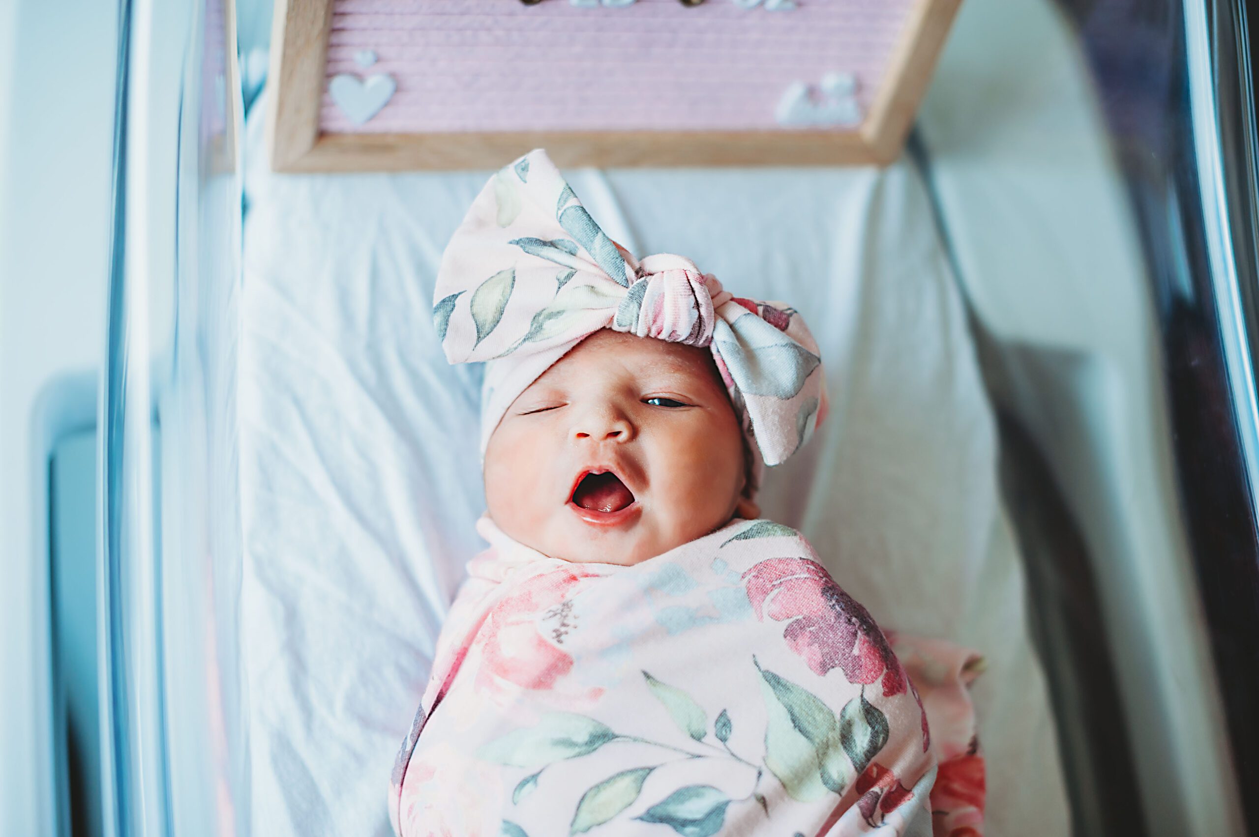 A newborn baby girl is in her bassinet in a fresh 48 session by Splendor Photography