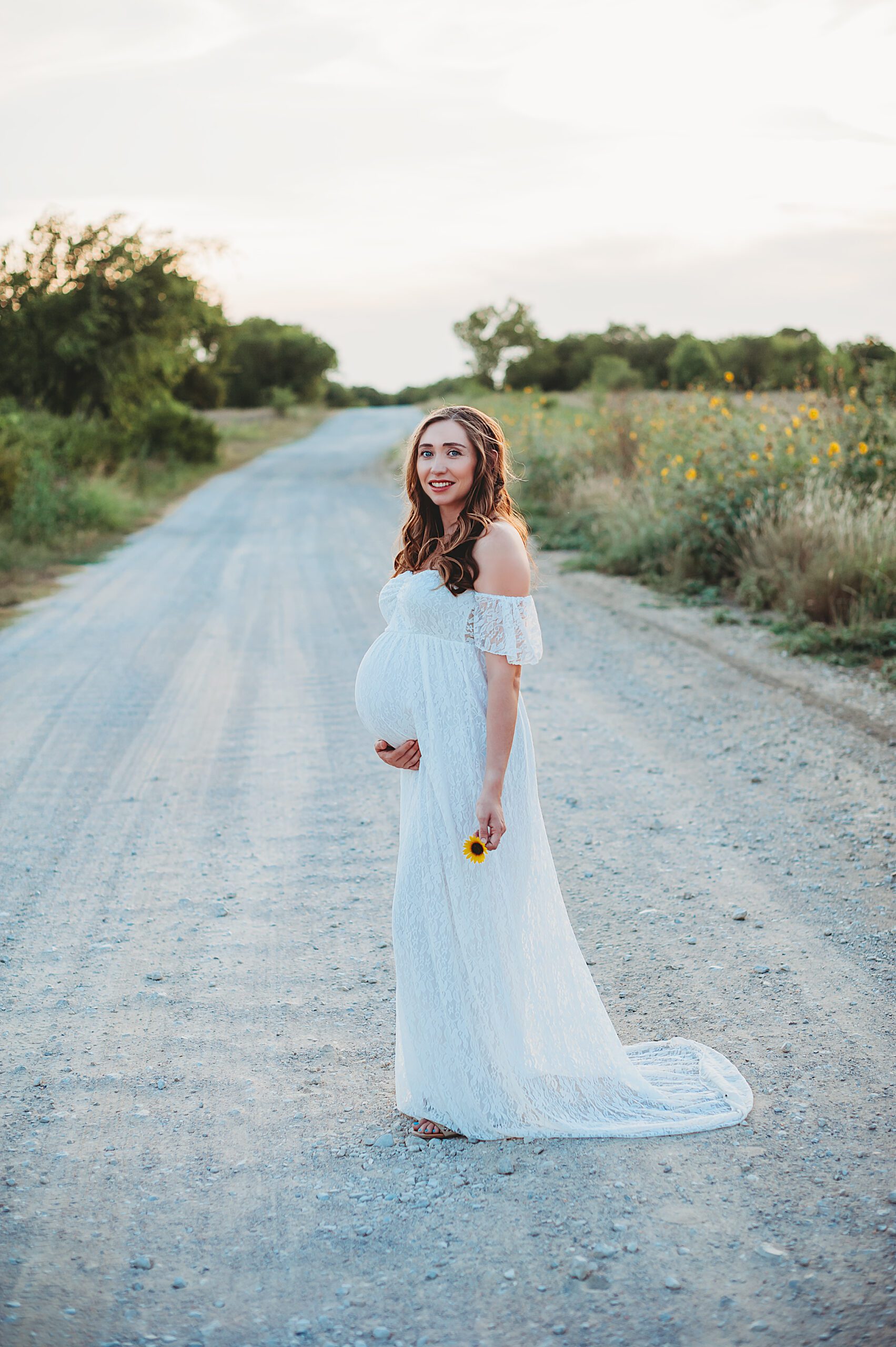 Fort Worth Maternity Photographers | Pregnant woman standing on a gravel road.